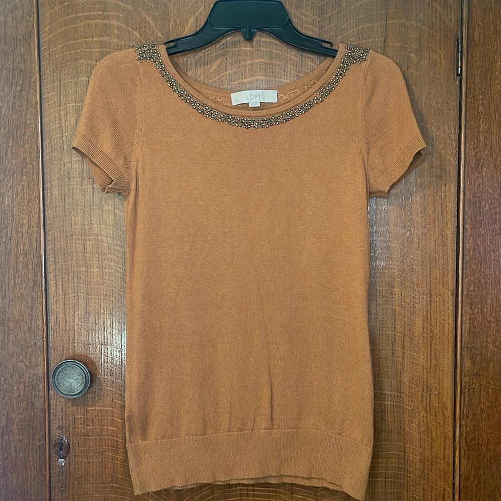 Short sleeved sweater with beaded neckline.